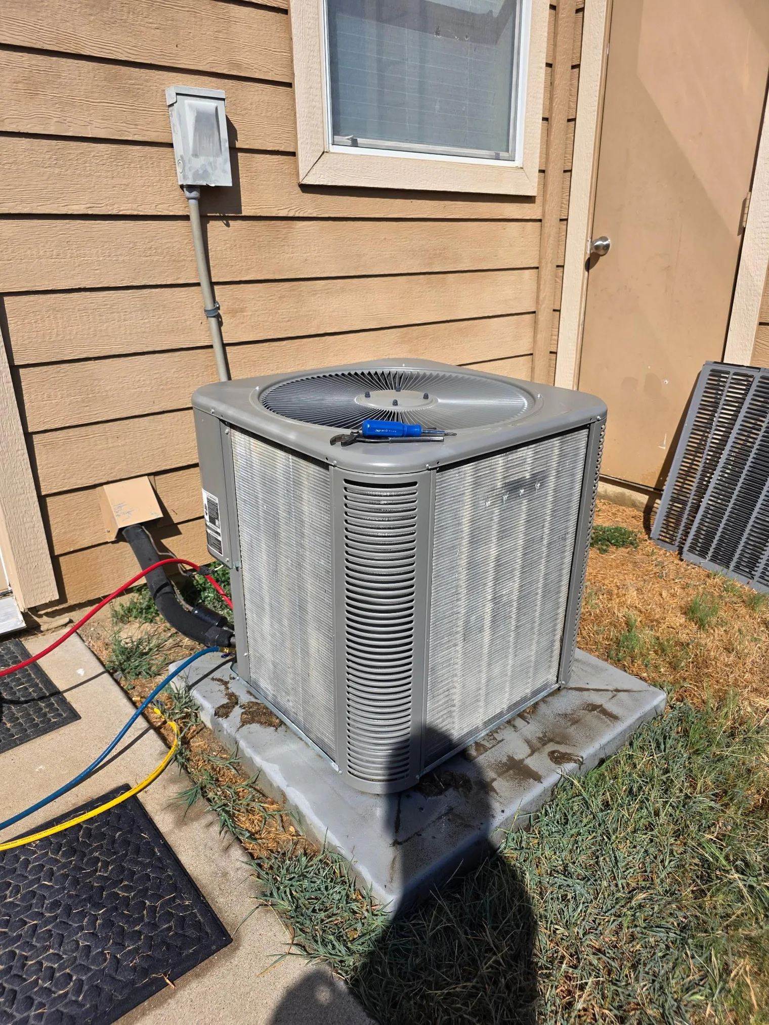 The same outdoor AC condenser after cleaning, with the aluminum coil fins washed clean and open