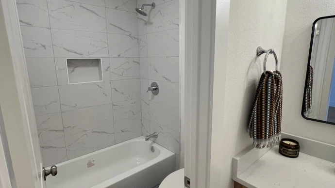 Modern bathroom with tub and white 12x24 tile