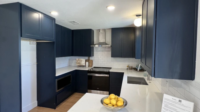 Modern kitchen with navy shaker doors and white quartz countertop